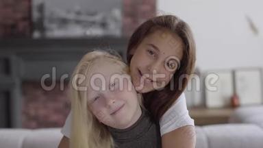 肖像可爱的小白化病女孩拥抱她的女朋友看着相机微笑。 友谊的概念。 免费